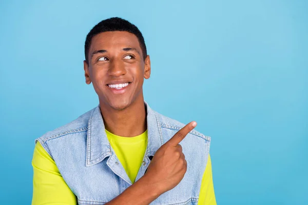 Foto de joven afro hombre mirada curiosa indican dedo vacío espacio aconseja promo aislado sobre fondo de color azul —  Fotos de Stock