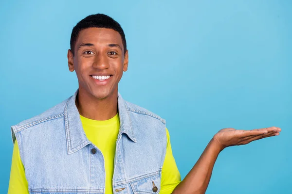 Foto de un joven y alegre promotor afro sostienen anuncios de recomendación de promoción de brazo aislados sobre fondo de color azul —  Fotos de Stock