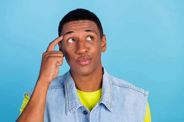 Foto do jovem cara africano dedo toque cabeça sonhadora considerar olhar espaço vazio isolado sobre fundo de cor azul — Fotografia de Stock