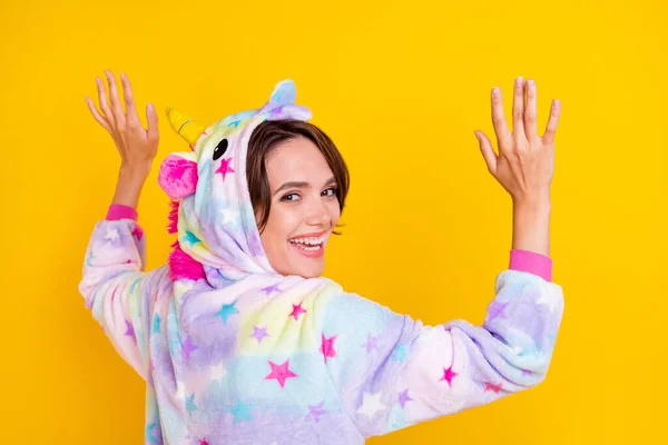 Photo portrait back view woman in unicorn costume smiling in hood isolated bright yellow color background — Stock Photo, Image