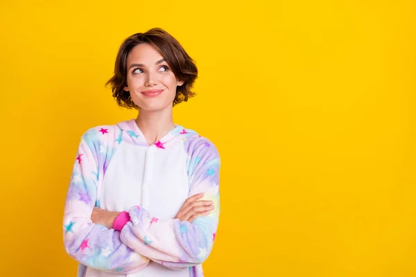 Foto porträtt flicka bob frisyr leende korsade händer i pyjamas ser copyspace isolerad levande gul färg bakgrund — Stockfoto