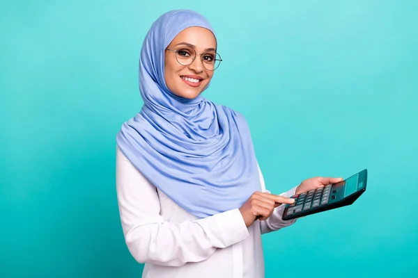 Fénykép csinos bájos fiatal hölgy öltözött iszlám hidzsáb szemüveg mosolygós számolás fizetés elszigetelt rózsaszín háttér — Stock Fotó