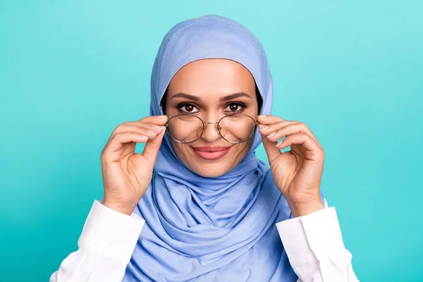 Foto di affascinante bella giovane donna indossare arabo velo braccia occhiali sorridente isolato turchese colore sfondo — Foto Stock