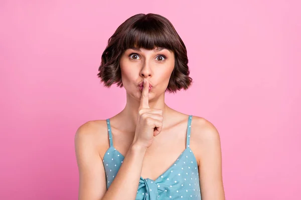 Portret atrakcyjnej tajemniczej brązowłosej dziewczyny pokazujący shh znak izolowany nad różowym pastelowym tle koloru — Zdjęcie stockowe