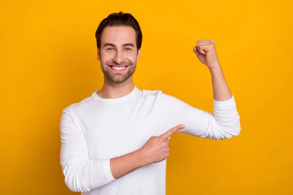Photo de l'homme positif joyeux bras de doigt direct montrant biceps isolés sur fond de couleur jaune — Photo