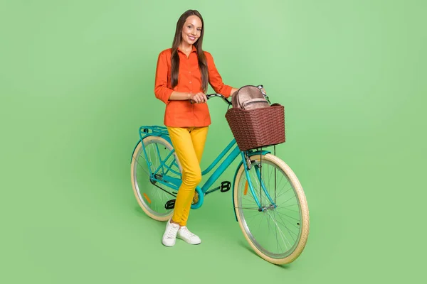 Pełnowymiarowe zdjęcie wesołej dojrzałej kobiety spędzają wolny czas jeżdżąc na rowerze odizolowany na zielonym tle koloru — Zdjęcie stockowe
