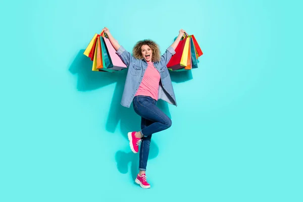 Foto de agradável louco despreocupado shopaholic senhora segurar pacotes loja desgaste jeans camisa isolado teal cor fundo — Fotografia de Stock