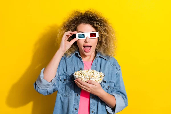 Bild av dam håll popcorn öppen mun titta på bio premiär bära 3D glasögon jeans skjorta isolerad gul färg bakgrund — Stockfoto
