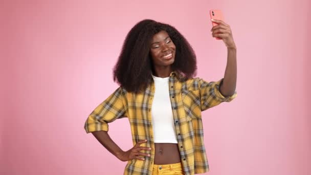 Dame faire selfie gadget montrer v signe coup baiser isolé couleur rose fond — Video