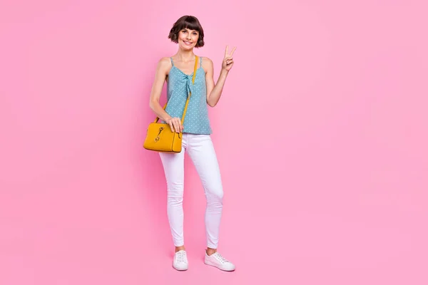 Vista completa del tamaño del cuerpo de la encantadora chica delgada alegre que muestra el buen humor v-signo aislado sobre el fondo de color pastel rosa — Foto de Stock