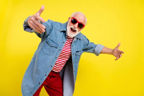 Πορτρέτο της ελκυστική χαρούμενα κωμικό παιδαριώδη γκριζομάλλης άνθρωπος χορό διασκεδάζοντας απομονωμένη πάνω από φωτεινό κίτρινο χρώμα φόντο — Φωτογραφία Αρχείου