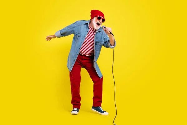 Ganzkörpergröße Ansicht der attraktiven fröhlichen grauhaarigen Mann singen Hit Spaß isoliert über lebendige gelbe Farbe Hintergrund — Stockfoto