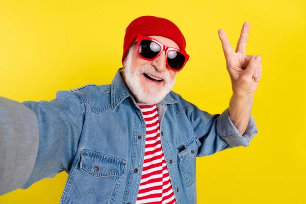 Selbstporträt von älteren Rentner fröhlich grauhaarigen Mann zeigt V-Zeichen isoliert über leuchtend gelben Farbhintergrund — Stockfoto