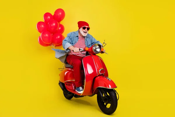 Emekli yaşlı adam portresi. Neşeli adam motosiklete biniyor. Canlı sarı arka planda izole edilmiş eğleniyor. — Stok fotoğraf