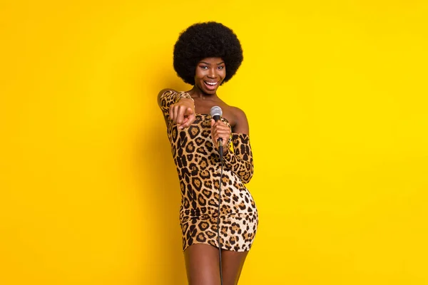 Foto porträtt kvinna bär leopard klänning sång på scenen pekar på dig isolerad levande gul färg bakgrund — Stockfoto
