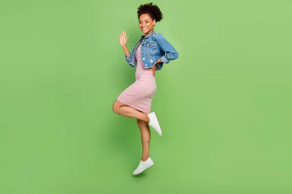 Teljes test profil fotó a hűvös fiatal hölgy ugrás ruha ruha póló cipő elszigetelt zöld háttér — Stock Fotó