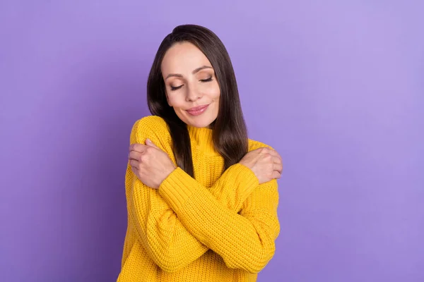 Фото оптимистичной брюнетки зрелой дамы обниматься носить желтый свитер изолированы на фиолетовом фоне цвета — стоковое фото