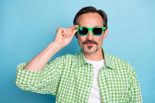 Retrato de conteúdo atraente homem funky tocando especificações olhar agradável compras isolado sobre fundo de cor azul brilhante — Fotografia de Stock