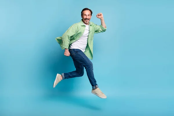 Повнометражний вигляд на тіло привабливого веселого чоловіка, який стрибає, розважаючись ізольовано на яскраво-синьому кольоровому фоні — стокове фото