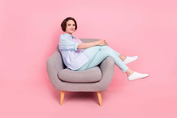 Full längd kropp storlek foto ung kvinna sitter i fåtölj bär casual outfit isolerad pastell rosa färg bakgrund — Stockfoto