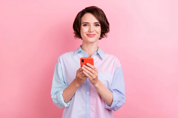 Foto de mujer joven feliz sonrisa positiva navegar teléfono inteligente chat sms aislado sobre fondo de color rosa —  Fotos de Stock