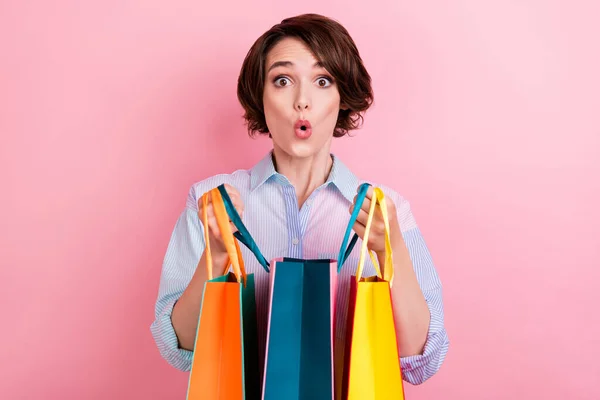 Фото молодой женщины удивлен удивлен удивлен omg вау провести покупки сумки продажи изолированы на розовом фоне — стоковое фото
