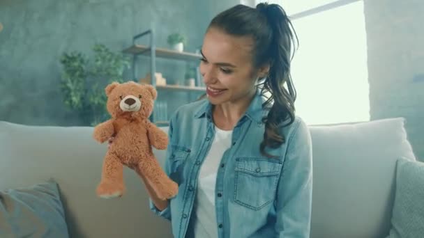 Infantil juguetona dama sentarse sofá disfrutar de tiempo libre abrazar peluche oso juguete — Vídeos de Stock