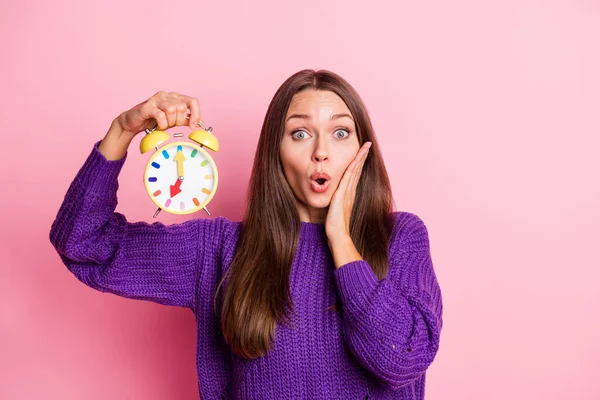 Foto gadis terkesan menunjukkan tangan jam wajah mengenakan sweater ungu terisolasi di latar belakang warna merah muda pastel — Stok Foto