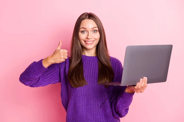 Zdjęcie optymistycznej dziewczyny trzymać laptop pokazać kciuk do góry nosić sweter liliowy izolowane na różowym tle koloru — Zdjęcie stockowe