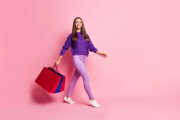 フルサイズプロフィール写真の楽観的な女の子行くホールドバッグ着用ライラックセーターパンツスニーカー隔離上ピンクの背景 — ストック写真