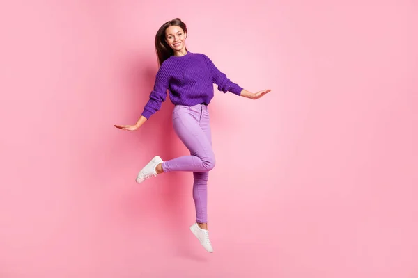 Foto de tamaño completo de chica optimista salto danza desgaste lilas suéter pantalones zapatillas aisladas sobre fondo rosa — Foto de Stock