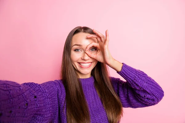 Portrét veselé mladé dámy, aby selfie ruce prsty ukazují binokulární gesto v blízkosti oka izolované na růžovém pozadí — Stock fotografie
