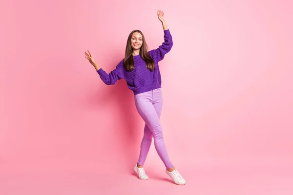 Volledige lengte foto van dame dans verhogen handen dragen paarse trui broek schoeisel geïsoleerde roze kleur achtergrond — Stockfoto