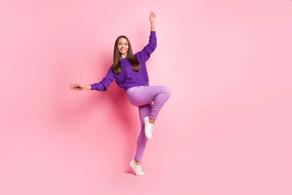 Teljes hosszúságú fotó a tánc emelje térd kar viselni lila pulóver nadrág cipők elszigetelt rózsaszín háttér — Stock Fotó