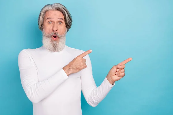 Retrato de atractivo hombre de pelo gris asombrado demostrando copia espacio en blanco anuncio anuncio mirada idea aislada sobre fondo de color azul brillante —  Fotos de Stock