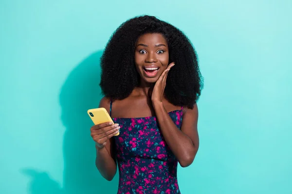 Foto portret vrouw glimlachend verbaasd lezen nieuws op smartphone geïsoleerd op levendige turquoise kleur achtergrond — Stockfoto
