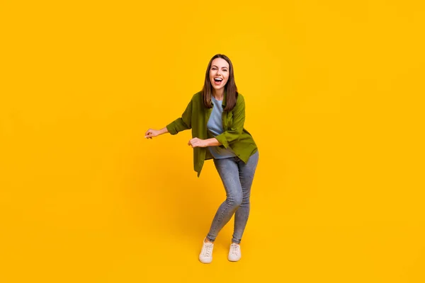 Photo of funny charming young lady wear green shirt smiling dancing isolated yellow color background — Stock Photo, Image