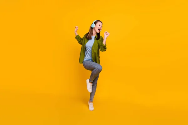 Photo of adorable shiny young lady wear green shirt earphones smiling singing dancing isolated yellow color background — Stock Photo, Image