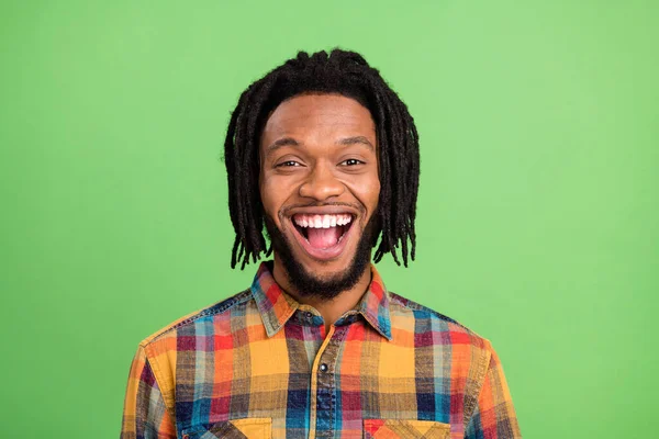 Foto van vrij opgewonden donkere huid man dragen geruite shirt glimlachen open mond geïsoleerde groene kleur achtergrond — Stockfoto