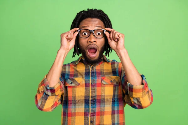 Foto de divertido sorprendido hombre de piel oscura usar camisa a cuadros brazos gafas boca abierta aislado color verde fondo —  Fotos de Stock