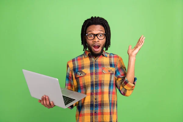 Photo of excited programmer guy hold pc open mouth wear checkered shirt isolated green color background — Stock Photo, Image