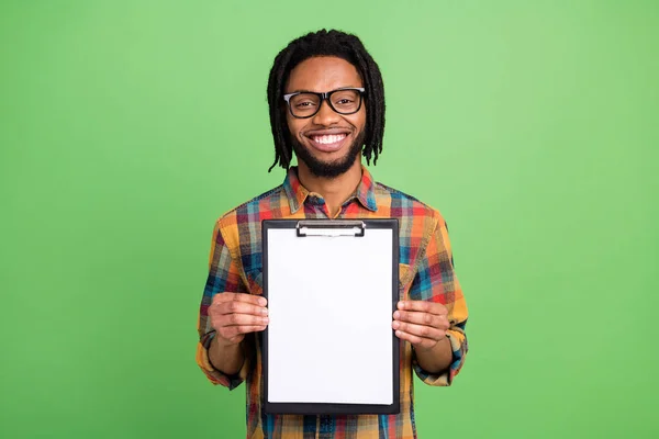 Photo of reliable african guy hold clipboard sign deal wear plaid shirt isolated green color background — Stock Photo, Image