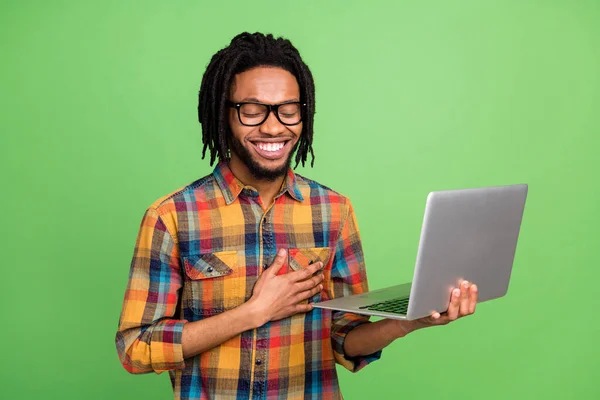 Foto van grappige charmante donkere huid man gekleed geruite shirt bril met moderne gadget lachen geïsoleerde groene kleur achtergrond — Stockfoto