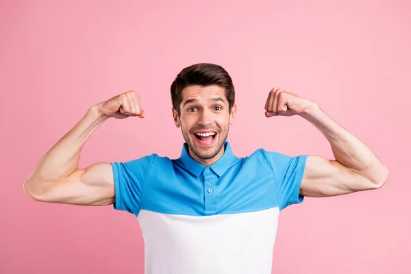 Portrét mladé dobré nálady vzrušený muž ukazuje svaly fit tělo superhrdina izolované na růžové barevné pozadí — Stock fotografie