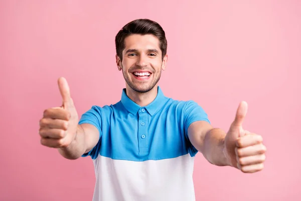 Foto de la encantadora morena millennial guy show thumb up wear camiseta azul aislado sobre fondo de color rosa —  Fotos de Stock