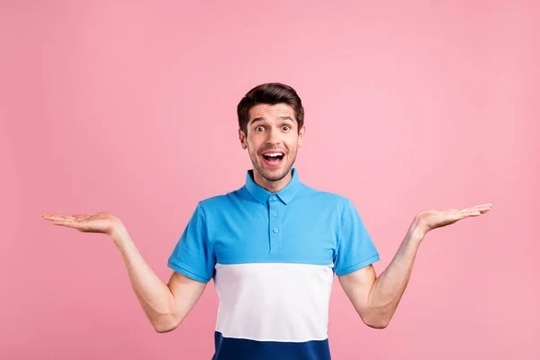 Foto de agradable morena millennial chico celebrar espacio vacío desgaste azul camiseta aislada sobre fondo de color rosa — Foto de Stock