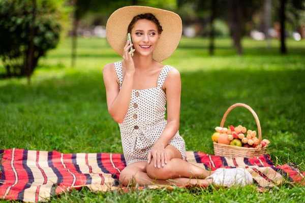 Foto de corpo inteiro de jovem atraente feliz mulher positiva sentar cobertor falar telefone desfrutar fora do parque ao ar livre — Fotografia de Stock