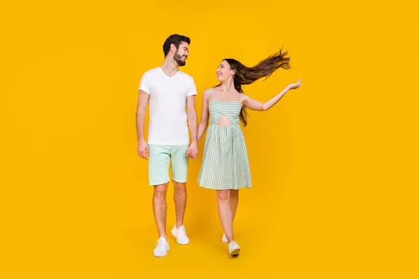Foto de casal inspirado no amor segurar as mãos desfrutar calçadão andar desgaste roupa casual isolado cor amarela fundo — Fotografia de Stock