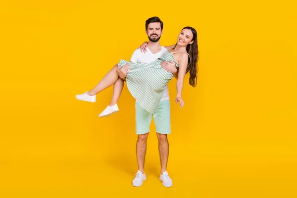 Fotografie páru v lásce spolehlivé vousatý muž držet přítelkyně nosit ležérní oblečení izolované žluté barvy pozadí — Stock fotografie