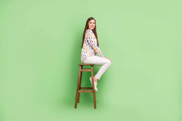 Foto de perfil de cuerpo completo de la divertida morena hairdo millennial lady sit wear blouse pantalones zapatillas aisladas sobre fondo verde — Foto de Stock